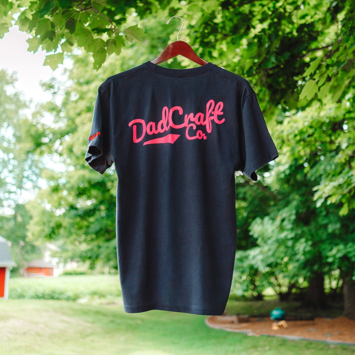 A Collaboration shirt between DadCraft and Superfly. Neon Paint splatter Superfly logo on the front with Neon Pink DadCraft Logo on the back