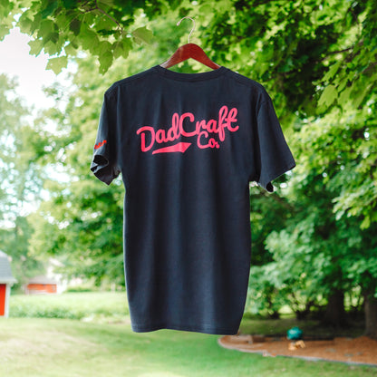 A Collaboration shirt between DadCraft and Superfly. Neon Paint splatter Superfly logo on the front with Neon Pink DadCraft Logo on the back