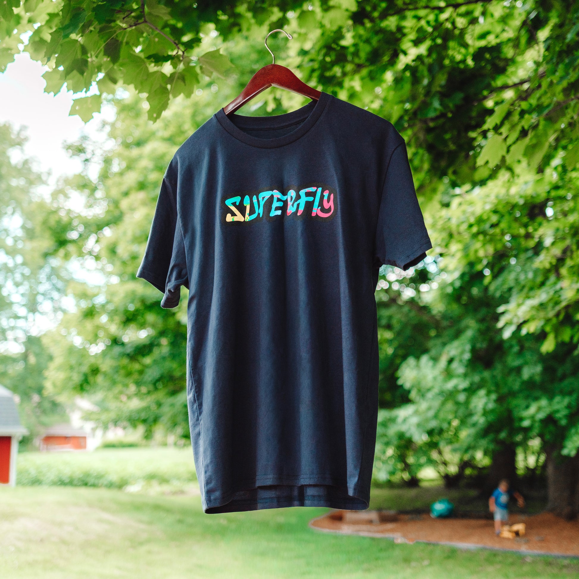 A Collaboration shirt between DadCraft and Superfly. Neon Paint splatter Superfly logo on the front with Neon Pink DadCraft Logo on the back